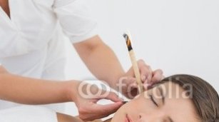 Beautiful_woman_receiving_ear_candle_treatment_at_spa_center.jpg